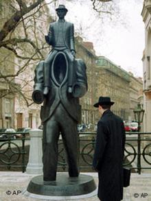 A passer-by looks at the Franz Kafka monument in Prague