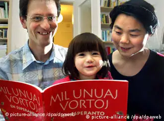 Matthias Ulrich and his wife Ms. Wang Nan Matthias read a children's book in Esperanto, with the title Mil Unuaj Vortoj (thousand first words), with their two year old daughter Christina in their home in Wiesbaden, a children's book in Esperanto, with the title Mil Unuaj Vortoj (thousand first words)