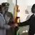 President Robert Mugabe, left shakes the hands of Morgan Tsvangirai, leader of the main opposition leader in Zimbabwe at the signing of a memorandum of understanding between the two parties in Harare