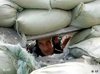 A Georgian soldier looks through the gun-port of his fortified foxhole