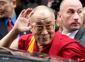 The Dalai Lama greets supporters as he leaves a Paris hotel
