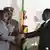 President Robert Mugabe, left, shakes hands with Morgan Tsvangirai, leader of the main opposition in Zimbabwe