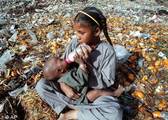 Auf Müll sitzendes Mädchen gibt Baby die Flasche (Quelle: AP)