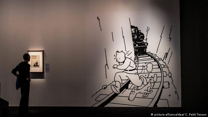 A visitor stands in front of a picture of comic character Tintin on display at the Herge exhibition