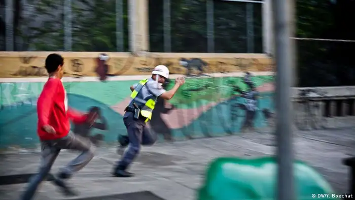 Policial militar de São Paulo é perseguido por manifestante após ficar isolado de sua tropa em um protesto em setembro de 2013, durante enfrentamento que deixou ao menos uma pessoa ferida gravemente.
