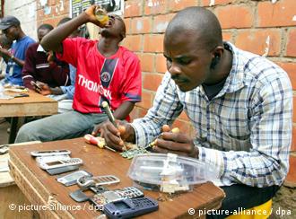 A man repairing a cell phone at a market in Abuja
