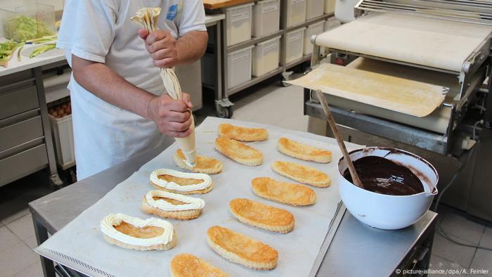Pastelitos de hojaldre en forma de suelas de zapatos, decorados con crema batida. 