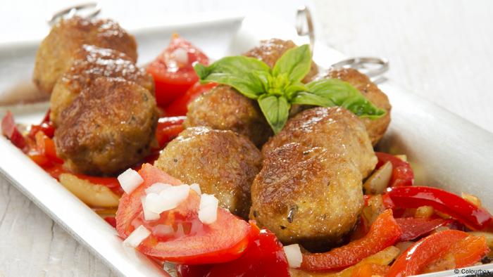 Albóndigas servidas en un plato con verduras. 