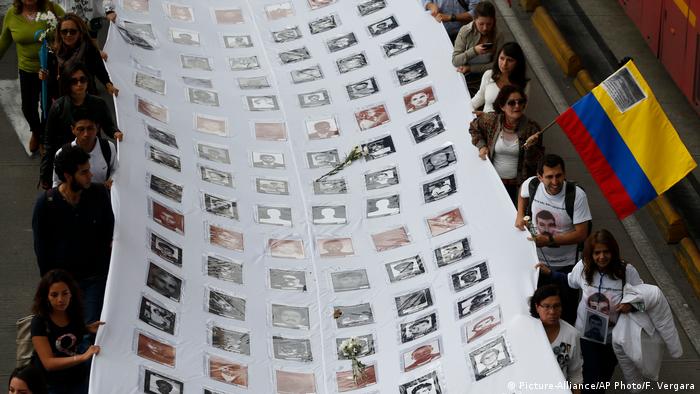 Una sábana blanca lleva las imágenes de miles de las 260.000 víctimas muertas en el conflicto, a manos de las guerrillas, los paramilitares y fuerzas militares del Estado. 