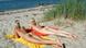 Two young women sunbathe naked on a beach Two young women sunbathe naked on a beach