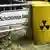 Gelbe Fässer mit dem Radioaktivitätszeichen neben einem Hinweisschild zur Schachtanlage Asse II (Foto: AP)