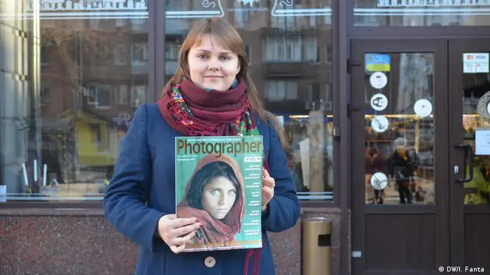 Yulia Melnyk holding an issue of Photographer magazine.