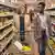 A German woman and a Nigerian refugee walk down a grocery store aisle in a scene from the 2016 movie Welcome to Germany