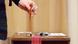 A woman casters her vote in a ballot box at a polling station in Iceland A woman casters her vote in a ballot box at a polling station in Iceland