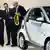 German Chancellor Angela Merkel, left, Matthias Wissmann, Chairman of the German Car Industry Association, second left, and Daimler AG CEO Dieter Zetsche, right, look at a power cable as they stand next to an electric powered vehicle during the 'e-mobility Berlin' event in Berlin, Germany, Friday, Sept. 5, 2008.