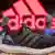 Кроссовки Adidas на фоне логотипа фирмы