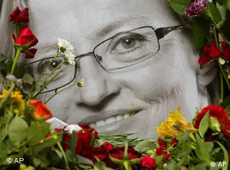 A portrait of late Swedish Foreign Minister Anna Lindh framed with flowers stands in front of a government building in Stockholm, Friday, Sept. 12, 2003. Lindh died Thursday after she was stabbed multiple times in an upscale Stockholm department store by an unknown assailant Wednesday. (AP Photo/Darko Vojinovic)