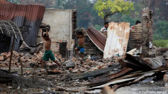 Children recycle goods from the ruins of a market which was set on fire at a Rohingya village outside Maugndaw in Rakhine state (Reuters/Soe Zeya Tun)