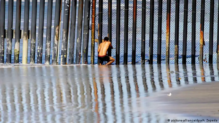 Am Grenzzaun zwischen Mexiko und USA steht ein Mexikaner und schaut durch die Stahlträger. (Foto: dpa)