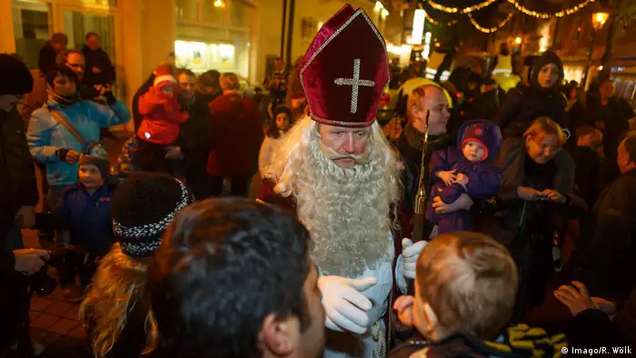 Der Heilige St. Nikolaus spricht auf dem Weihnachtsmarkt zu Kindern. (Imago/R. Wölk)