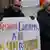 Участники акции протеста на Майдане с плакатом в руках