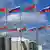 На флагштоках развеваются 18 поочередно расположенных флагов России и Беларуси