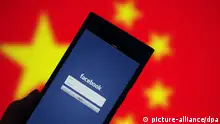 ARCHIV 2014 *** --FILE--The app of Facebook is used on a smartphone in front of a Chinese national flag in Ji'nan city, east China's Shandong province, 22 August 2014. Facebook Inc. is so keen to return to China that it built a tool that would geographically censor information in the country, according to media reports. While that may help the Chinese government get comfortable with Facebook, the company's re-entry may not happen for years, if at all, given licensing restrictions and other regulations that favor locally owned companies. China, which blocked the world's largest social network in 2009, has few incentives to allow the social network in. |