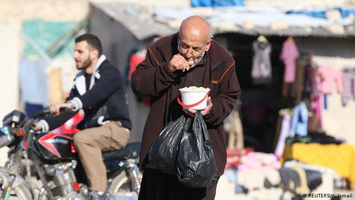 Syrien Mann versorgt sich an Essensausgabe in Aleppo