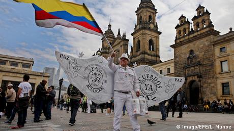 Un hombre con un traje con alas lleva la inscripción de los Acuerdos de Paz de Colombia.