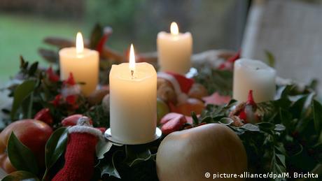 Advent wreath with four white candles, three of them lit 