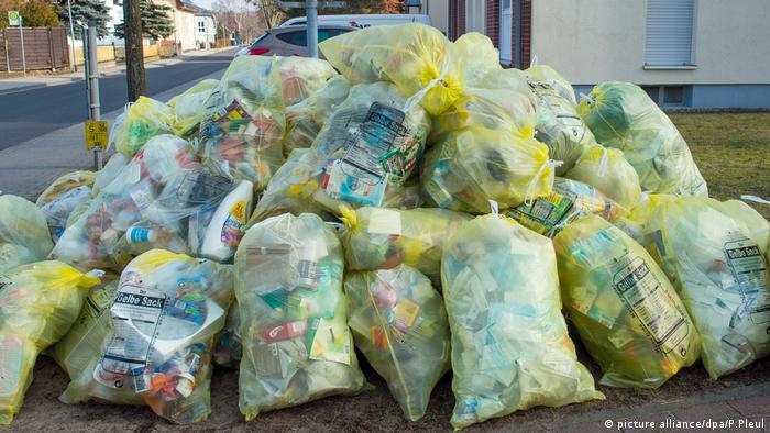 Kunststoffabfälle sind in gelben Müll-Säcken aufgetürmt. 