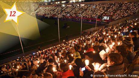 People singing Christmas songs in a stadium (picture-alliance/dpa/H. Kaiser)