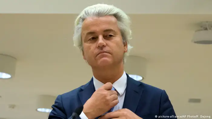 Geert Wilders adjusting his tie during a hate speech trial (picture-alliance/AP Photo/P. Dejong)