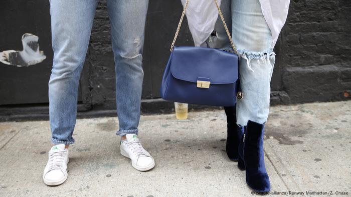 A close up of classic jeans and stoned washed jeans that are torn at the knee