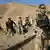 A German ISAF soldier in Afghanistan standing in front of Afghan men