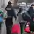 Migranci z bagażami w asyście policji 