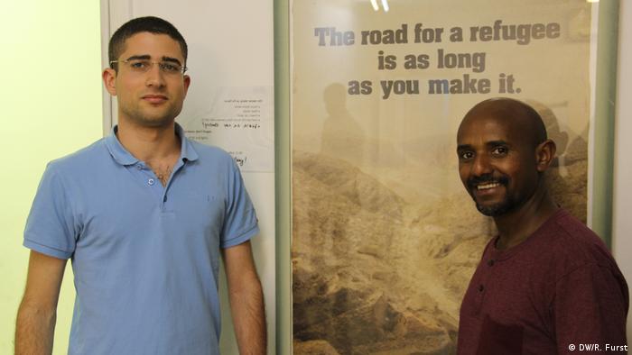 Or Mor (esq.), trabalhador do Centro Comunitário Africano de Jerusalém, ao lado de um imigrante