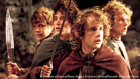 A still from The Lord of the Rings with four hobbits holding knives.