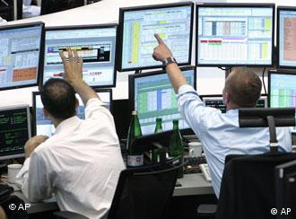 Brokers look at computer screens at the stock market