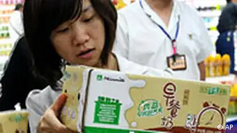A Chinese woman looks at the milk products on sale at a supermarket in Hangzhou in east China's Zhejiang province Wednesday, Oct. 8, 2008. China on Wednesday introduced standards for levels of the industrial chemical melamine permitted in milk and food products as it seeks to rein in a festering safety scare. The government has been struggling to deal with health and public relations issues stemming from the scandal, which erupted last month and is increasingly affecting China's food exports. (AP Photo) ** CHINA OUT **