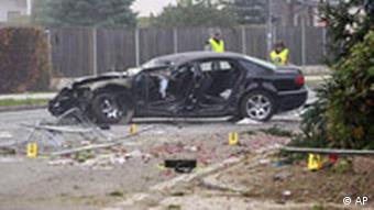Austrian police inspect the wreckage of Joerg Haider's car