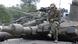 Israeli soldier checks his phone while sitting on a tank. Israeli soldier checks his phone while sitting on a tank.