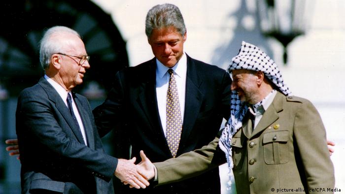 Israeli Prime Minister Yitzhak Rabin und PLO Chairman Yasser Arafat shake hands as President Bill Clinton looks on (picture-alliance/CPA Media )