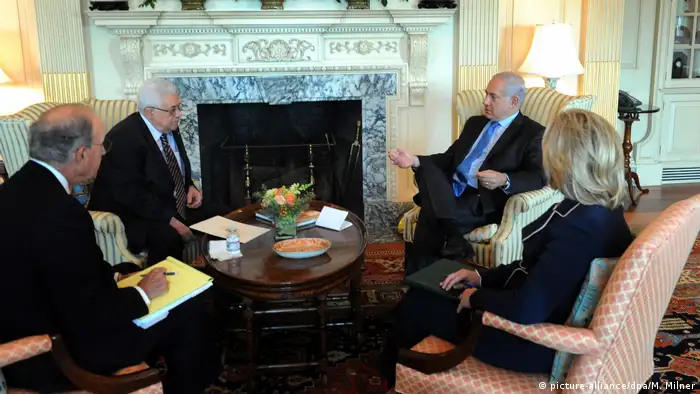 Israeli Prime Minister Benjamin Netanyahu speaks with Palestinian President Mahmoud Abbas as US Secretary of State Clinton and US envoy to the Middle East, George Mitchell, look on (picture-alliance/dpa/M. Milner)