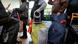 people standing in line with large bags people standing in line with large bags
