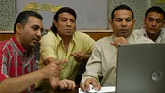 Teilnehmer sitzen vor einem Laptop.