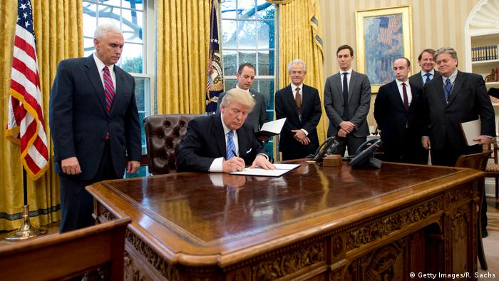 Trump signs one of his first Executive Orders in January with Bannon in the room