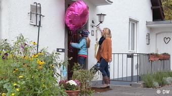 Mit einem Luftballon und einem Geschenk geht Emma zu Lottes Geburtstagsfeier.
