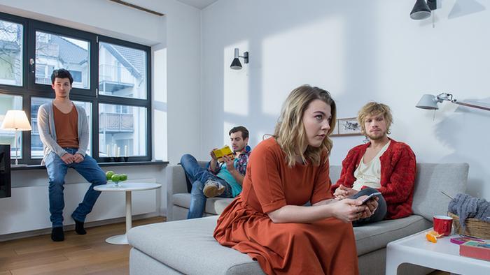 Vier Mitbewohner sitzen im WG-Wohnzimmer. (DW)
