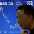 Chinese vor einer Anzeige mit fallendem Börsenindex. (Quelle: AP)